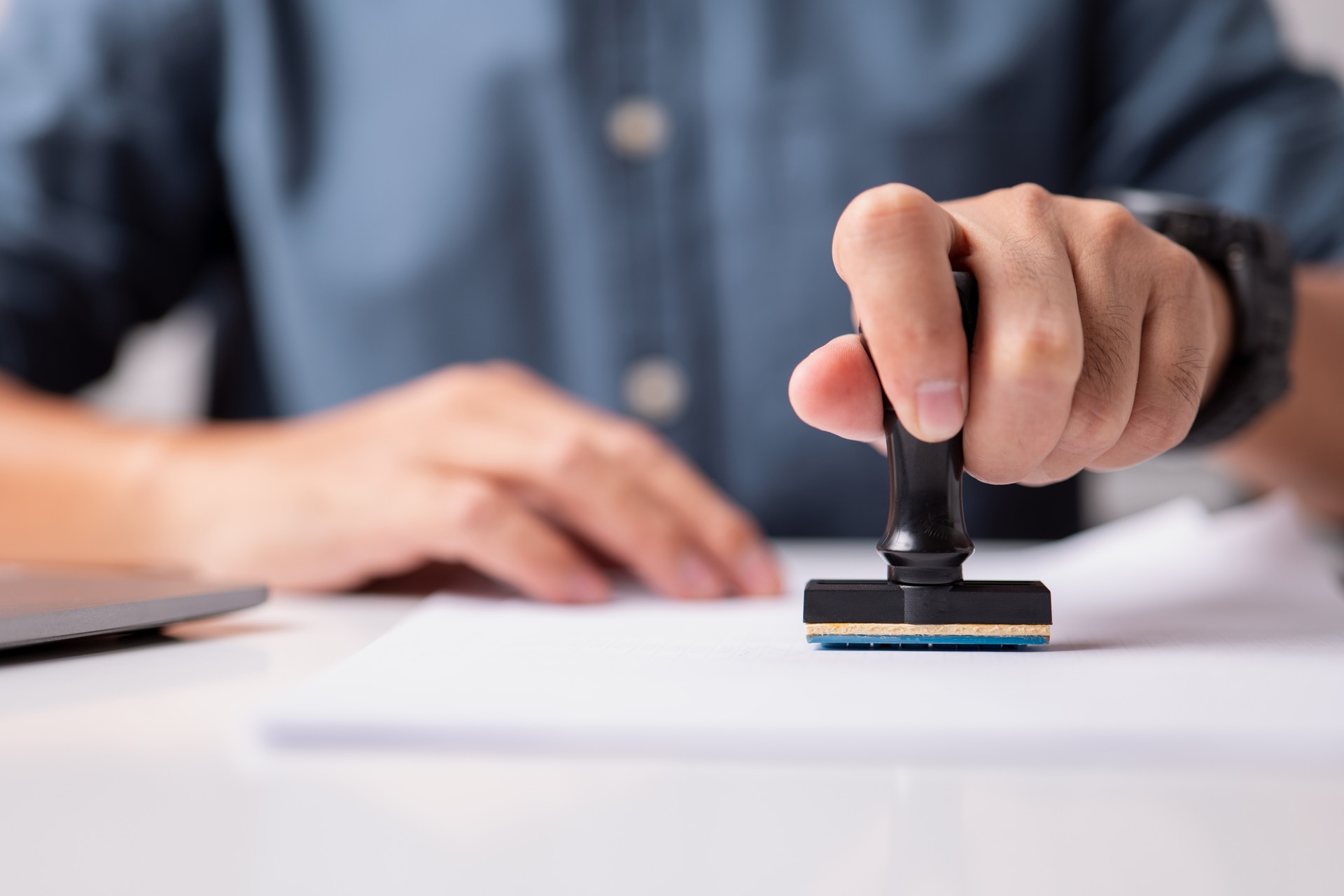 Close-up of a person's hand stamping on an approved application form