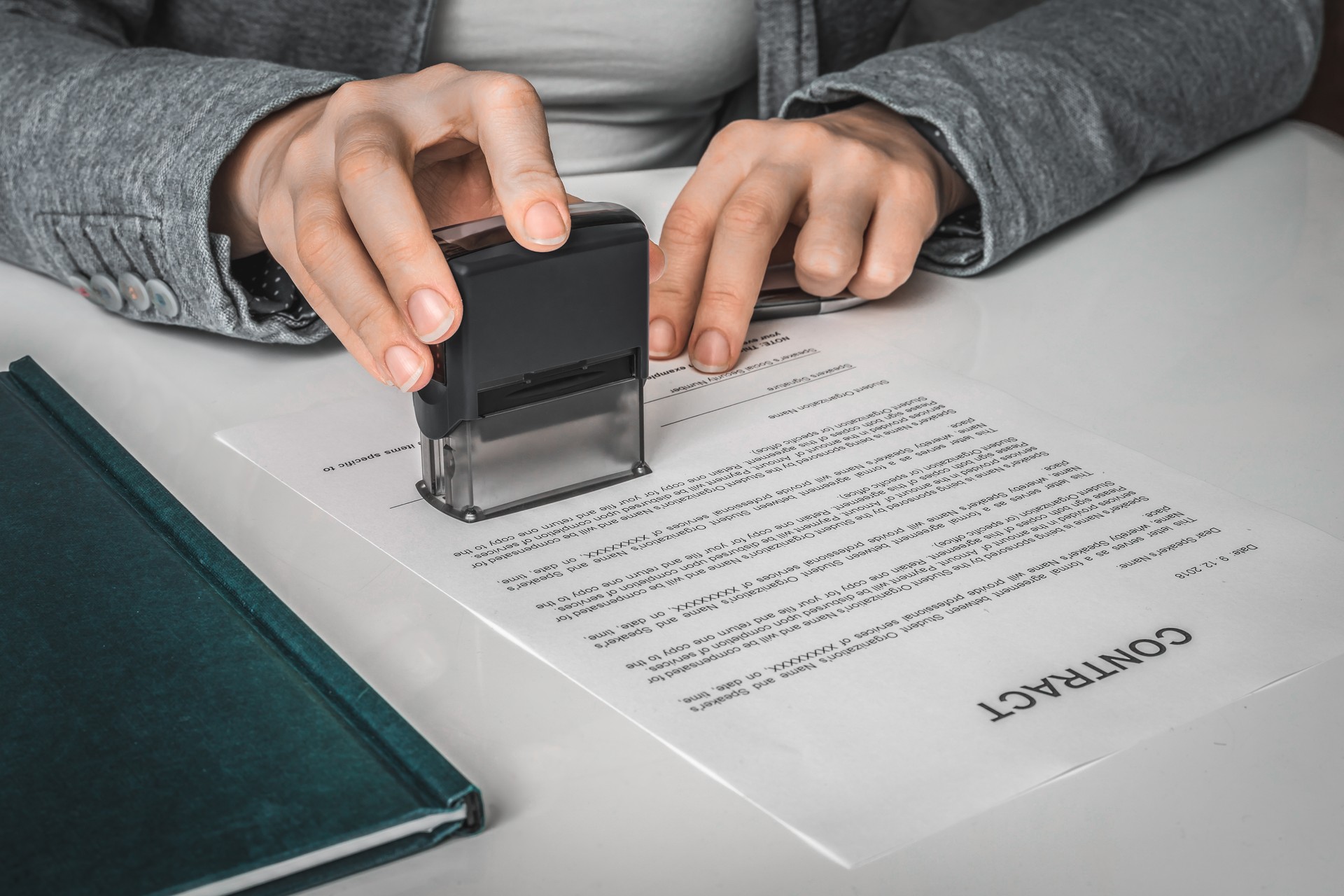 Business woman putting stamp on documents in the office